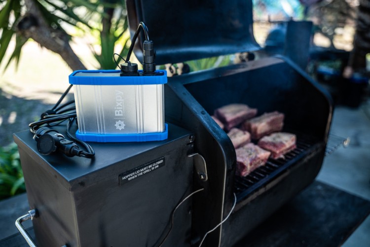 Bixpy Power Bank powering a grill that is cooking meat
